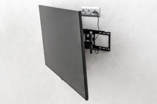 Modern tv hanging on the wall. Tv mounted with special fasteners in the room.